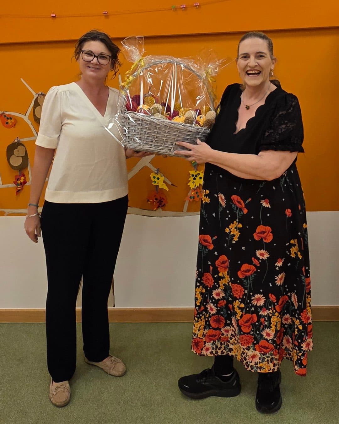 Christine von der Kinderkrippe Petitini und Sabine Roth halten gemeinsam den Geschenkkorb