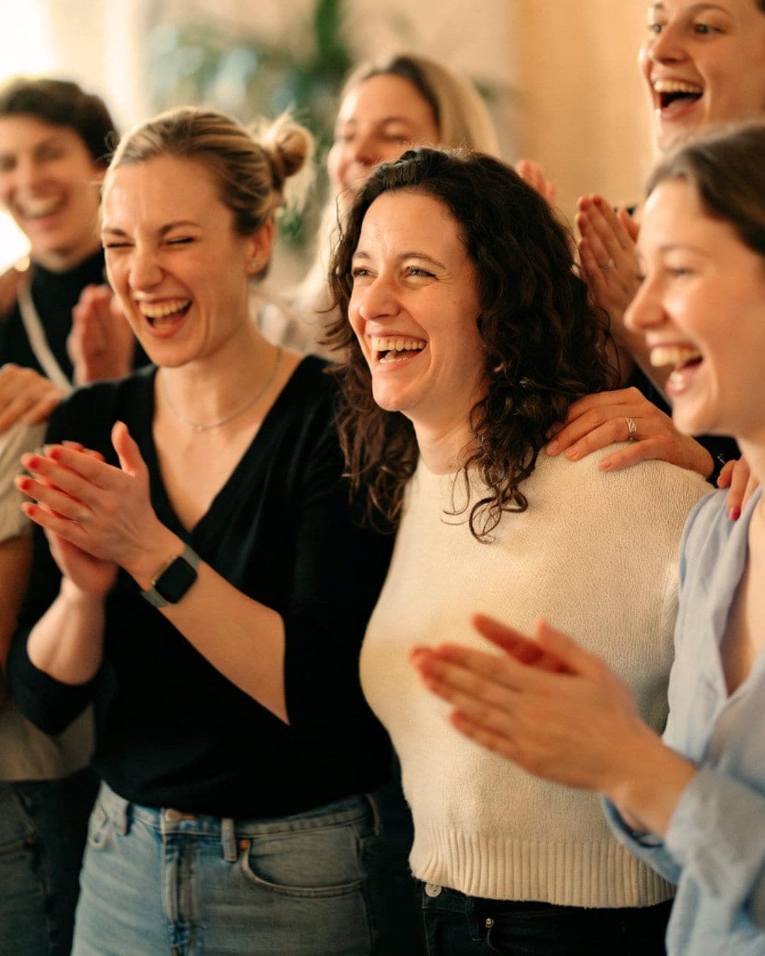 Ein Kita-Team lacht und klatscht im Seminar